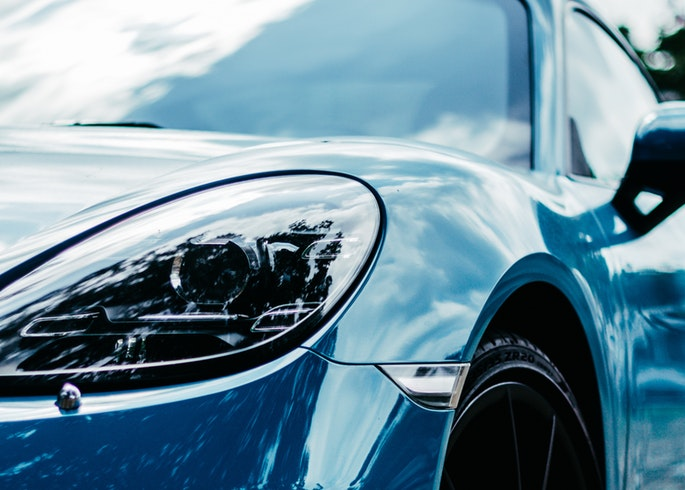 Close-up detail of luxury car showing pristine paint finish and headlight
