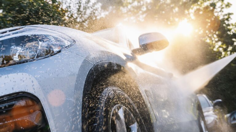 Car being washed with soap and water in beautiful golden sunlight, showing our professional detailing process