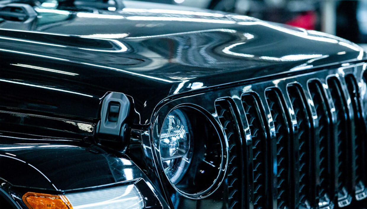 Close-up of perfectly detailed black vehicle showing mirror-like paint finish
