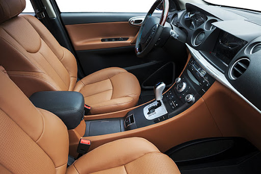 Luxury car interior with pristine tan leather seats showcasing professional detailing results