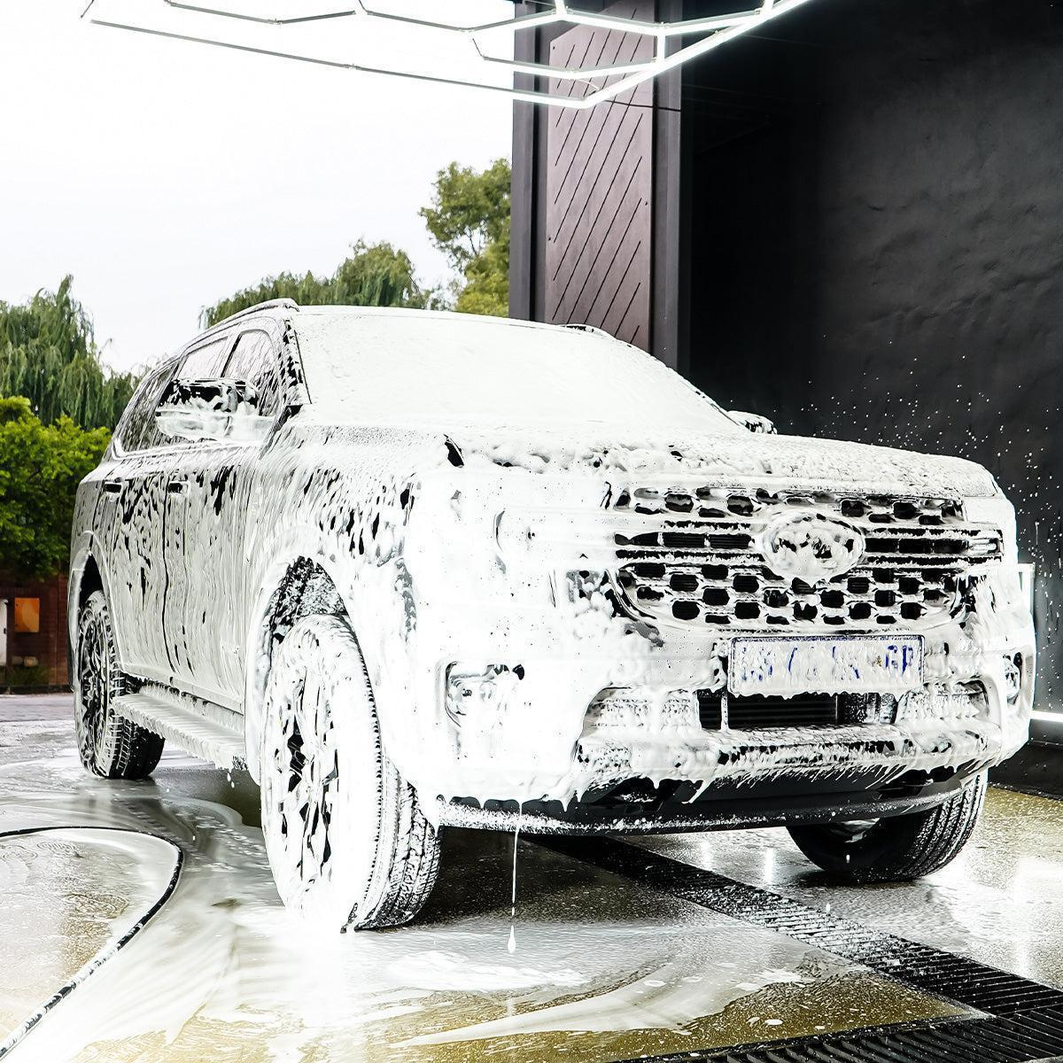 White SUV completely covered in soap foam during our thorough washing process